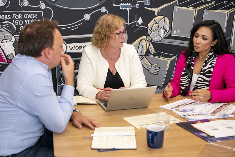 Colleagues discussing apprenticeship outcomes around a meeting table